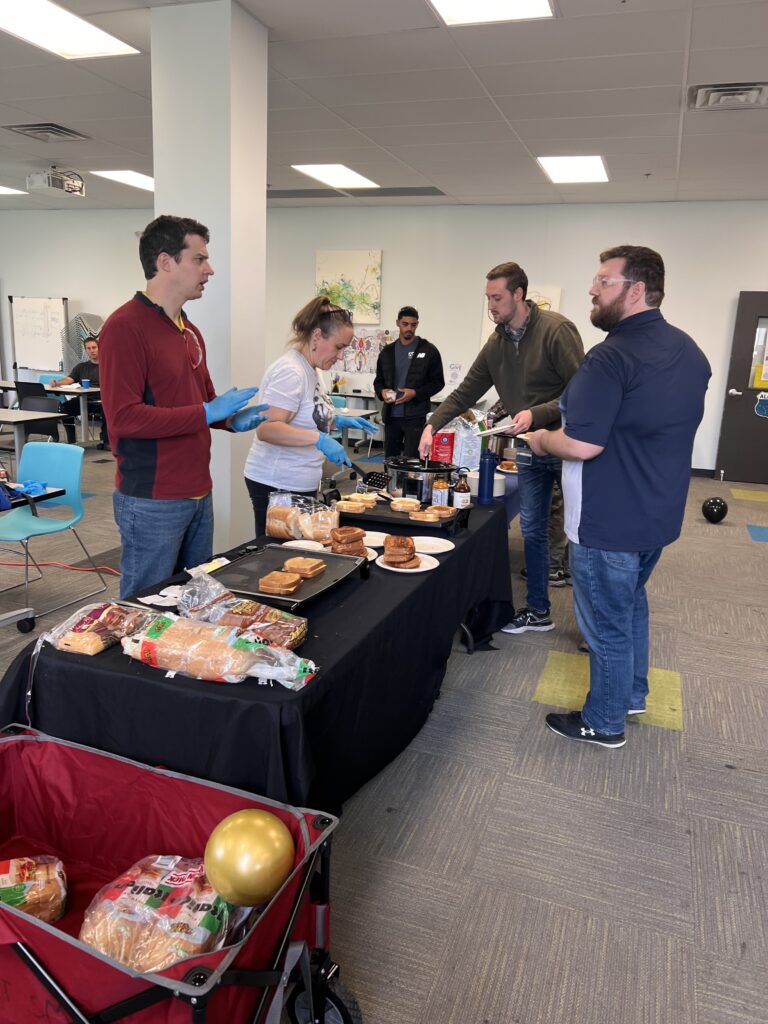 ACT's CSR group prepare grilled cheese sandwiches and celebrate ExtraGive donation totals rising.